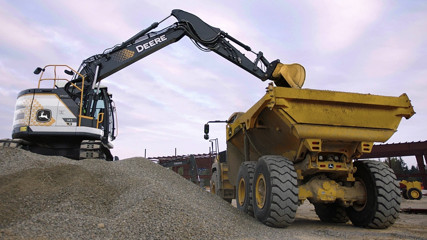 145 X-Tier E-Power Excavator loading materials into an ADT
