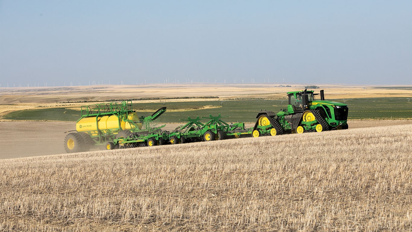 Side view of the new 9RX 830 tractor pulling a N560F ProSeries Air Hoe Drill and new C850T air cart through the field.