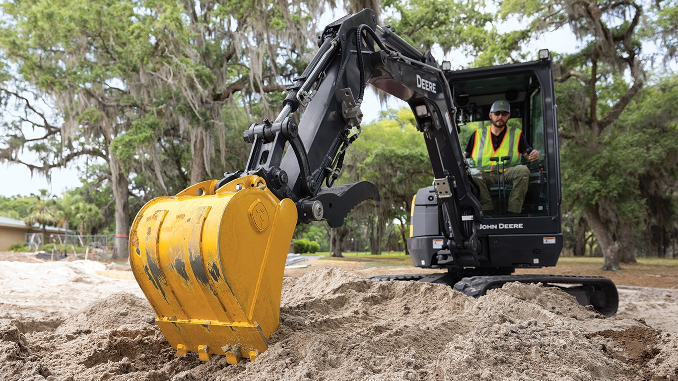 Ground-level shot of the 26 P-Tier Compact Excavator digging in the dirt