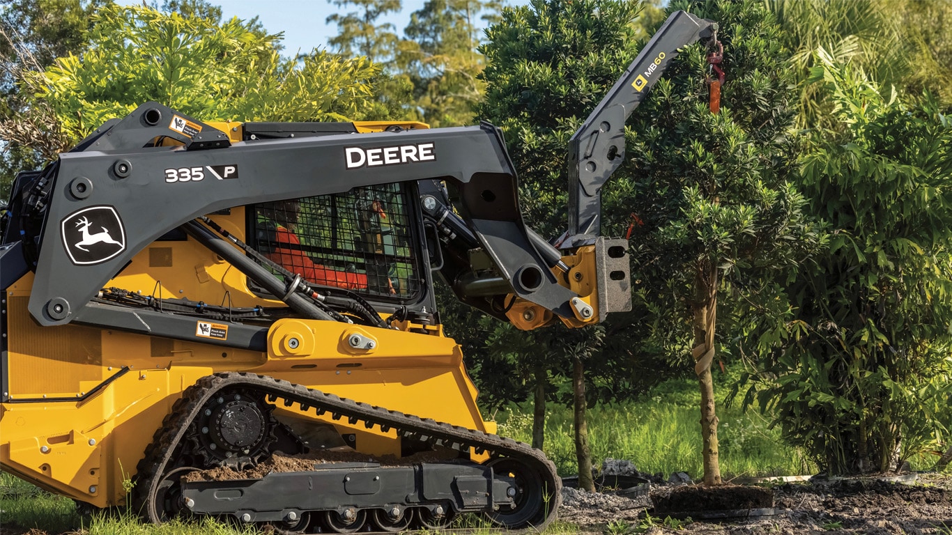 335 P-Tier using the MB60 Material Boom to lift a tree in a landscaped area