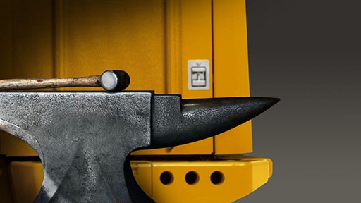 Un marteau et une enclume s'appuient contre une pièce d'équipement de construction
