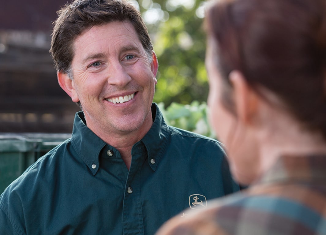 Homme en chemise John Deere discutant avec une femme