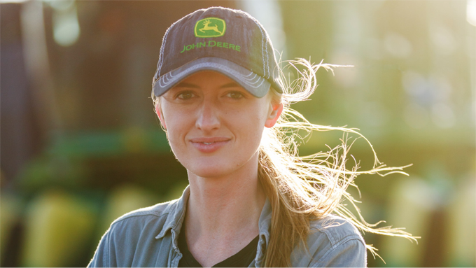 Woman smiling in John Deere baseball cap