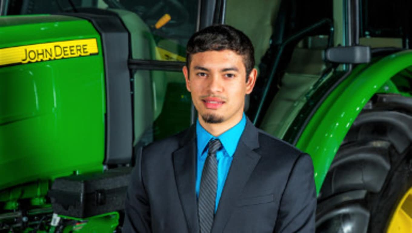 Michael stands in front of John Deere equipment