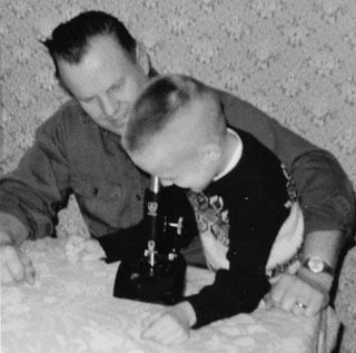 Noel Anderson utilisant un microscope lorsqu'il était un jeune enfant.