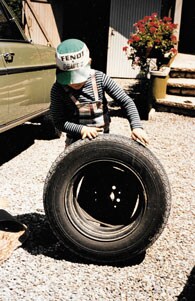 A young Martin Kremmer holds a tire while wearing a Fendt logo hat.