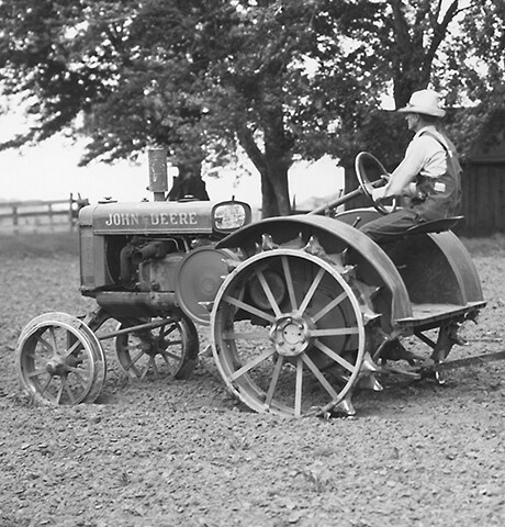 Tracteur à usage général « GP » de John Deere historique tirant une houe rotative numéro 7 de John Deere dans un champ