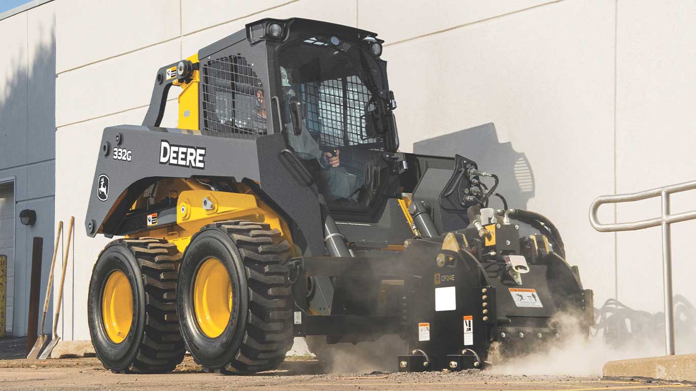 Action shot of a cold planer attached to a 332G skid steer loader