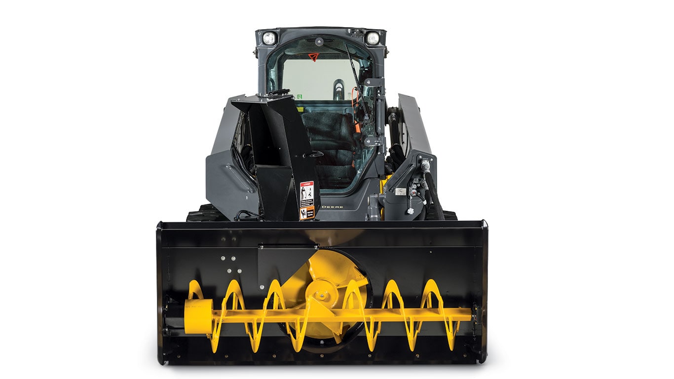 Frontal view of the new snow blower attachment attached to a skid steer loader