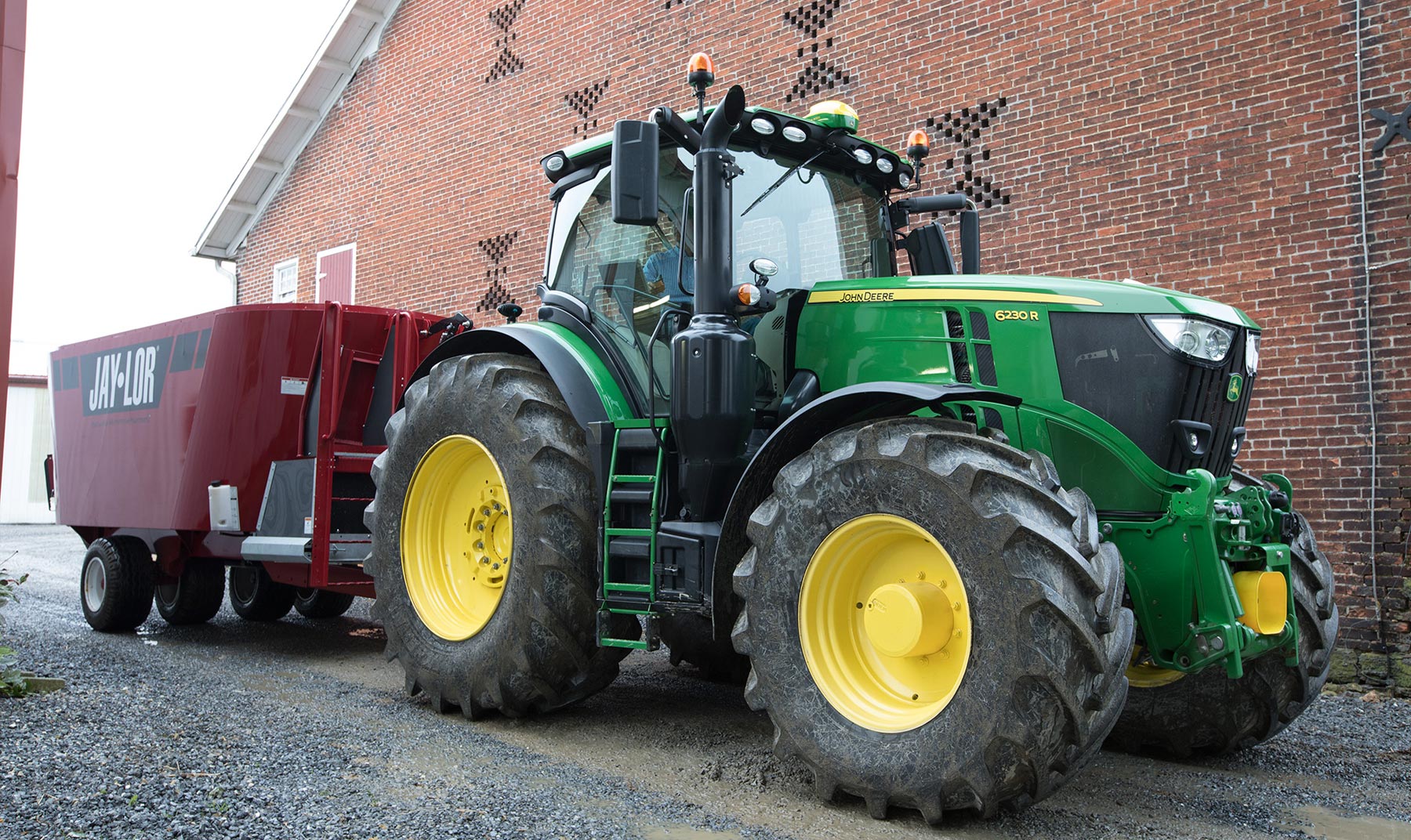 A 6230R tractor parked by a building