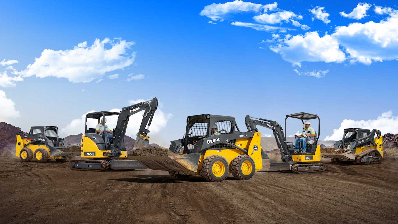 ive John Deere compact equipment machines lined up on job site
