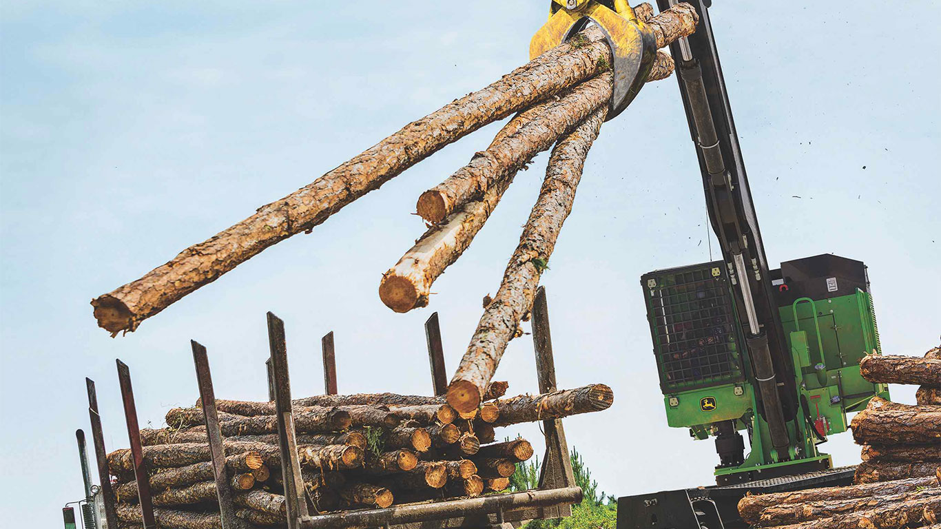 A knuckleboom loader on the job moving logs.
