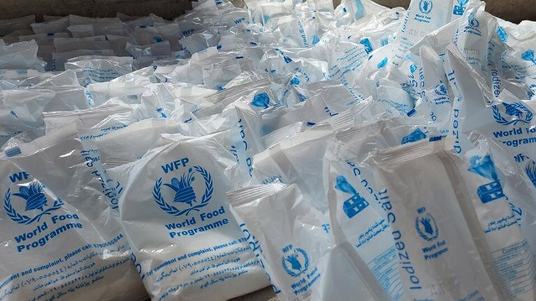 Une énorme pile de sacs du Programme alimentaire mondial remplis de ressources vitales pour l'Ukraine