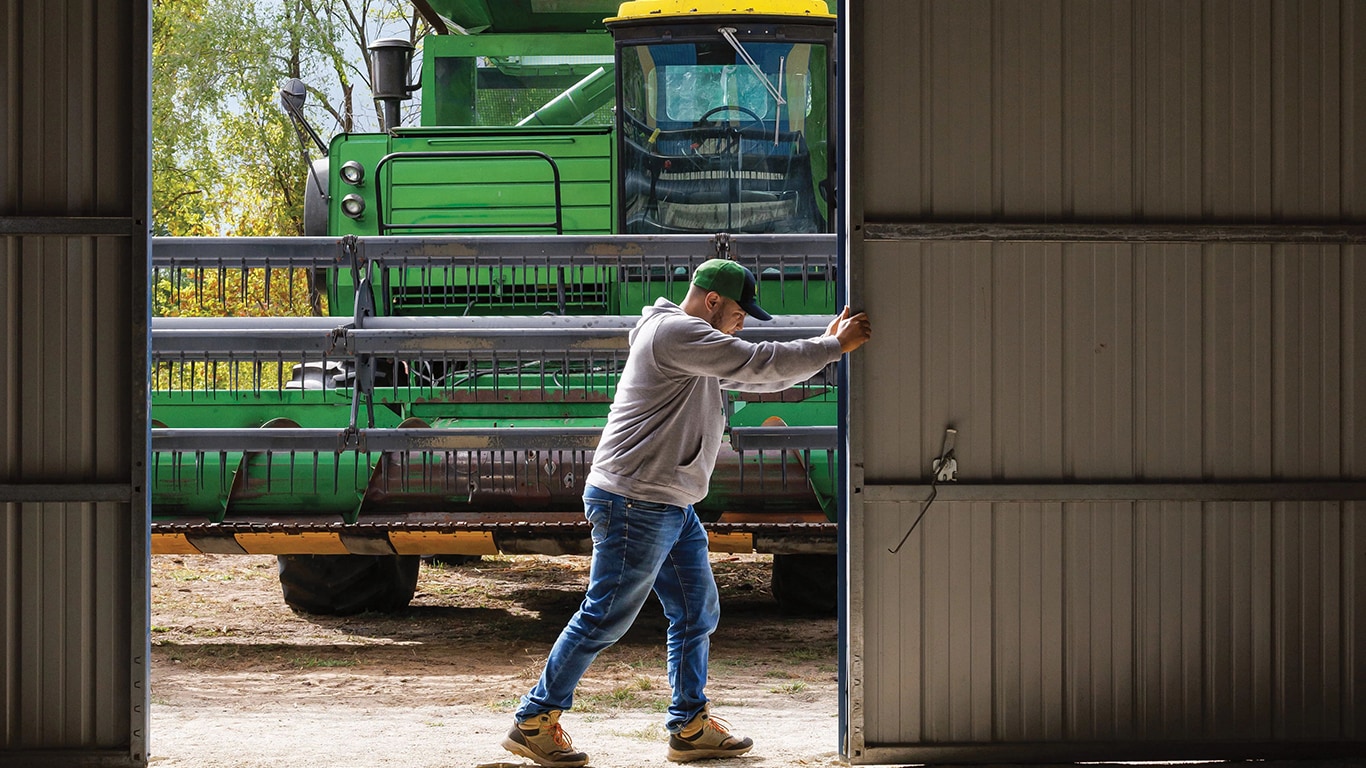 A Western Heritage farmer opens metal barn doors