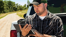 man looking at a tablet outside