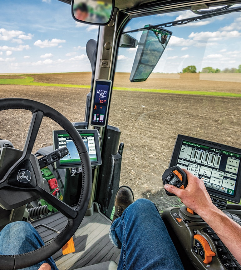 Photographie d'un homme dans la cabine d'un tracteur dans un champ