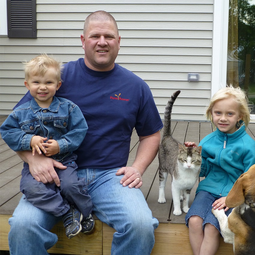 Matt Klemetson est assis sur son perron avec ses trois enfants, son chat et son chien.