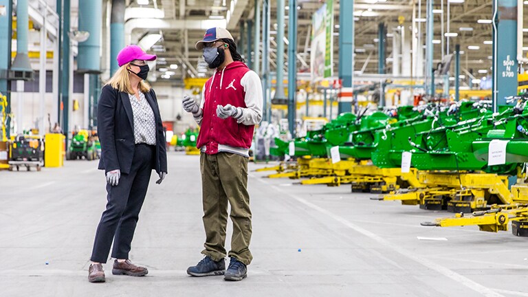 A female factory manager chatting with one of her employees