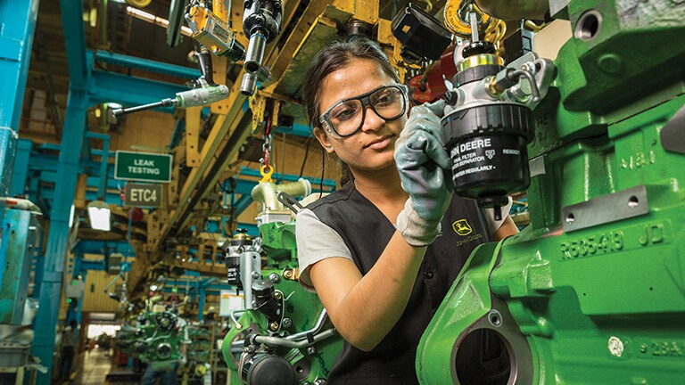 A woman from India building a John Deere machine