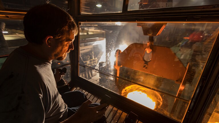 A man remotely pouring molten metal in the Waterloo factory