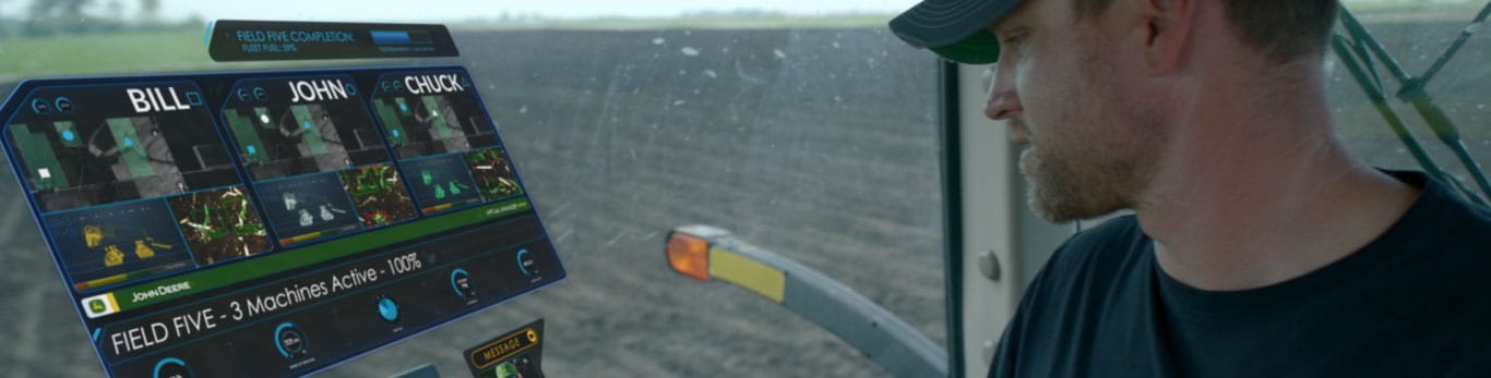 Man looking at holographic screenviews of field and staff production.