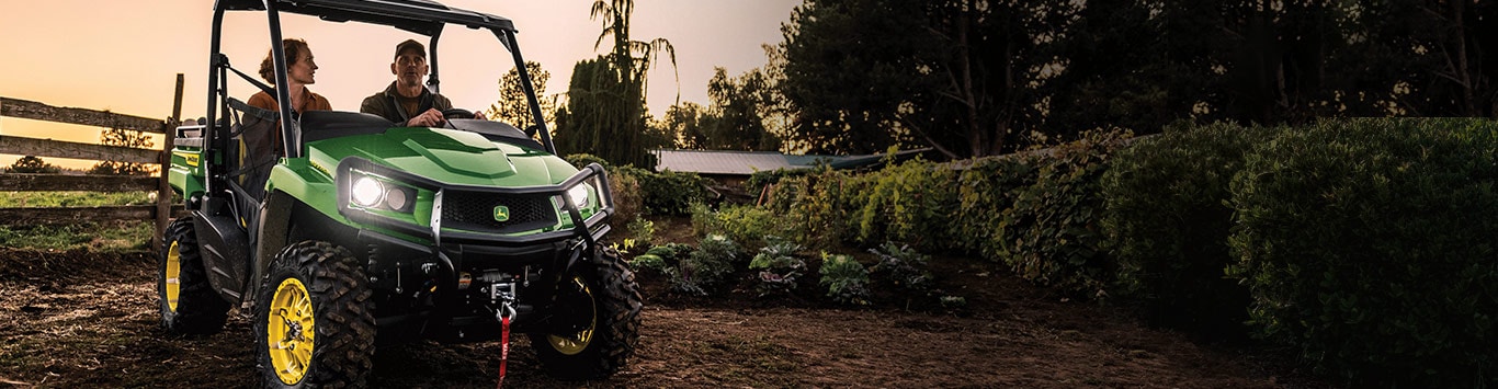 A couple ride their Gator at sunset