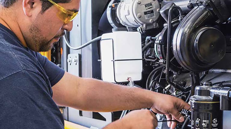 a man with safety glasses working on an engine