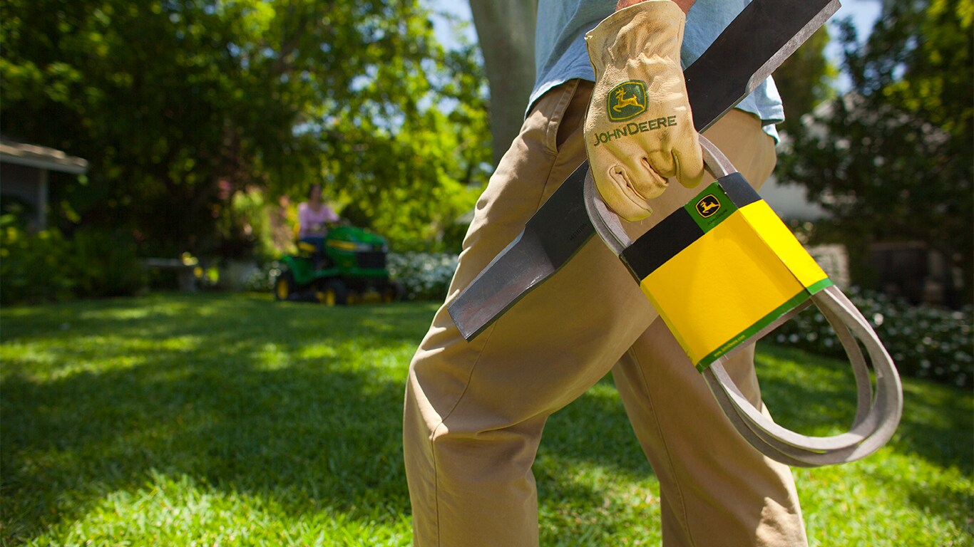 lawn mower belt and blade in a man's hand