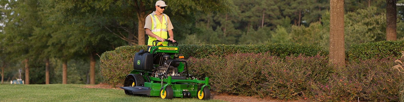 A man on a QuikTrak mower