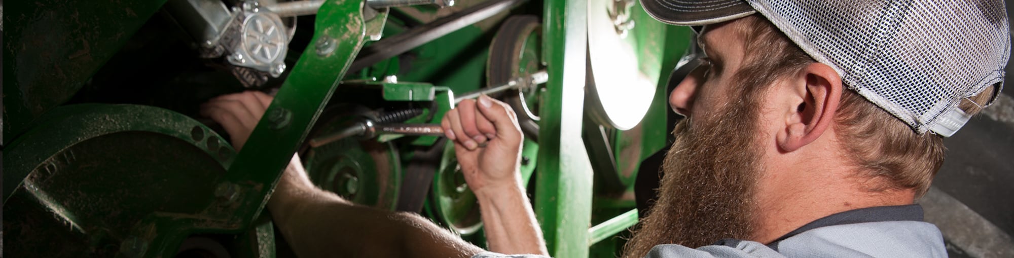 A technician examines the parts of a combine