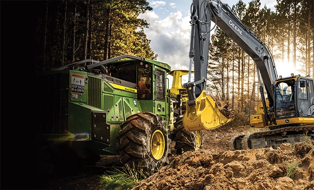 véhicule forestier et véhicule de construction devant une forêt