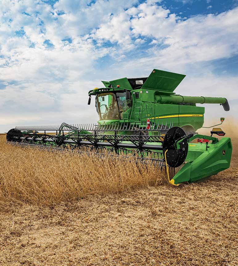 A John Deere combine harvests soybeans