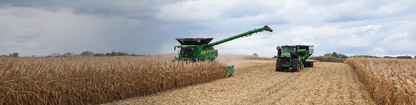 Tractor and harvester working through a field of wheat