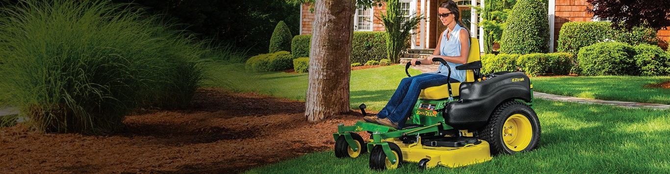 woman riding a EZtrak mower in her yard