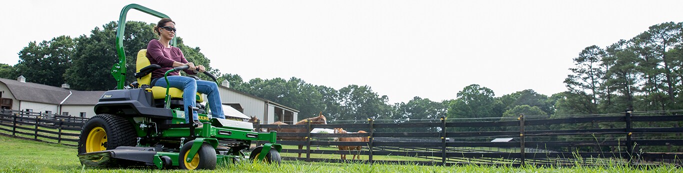 A woman riding a z760R near some horses