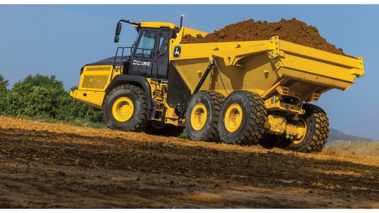 Side-view of a 310P Articulated Dump Truck with dirt in the bed.