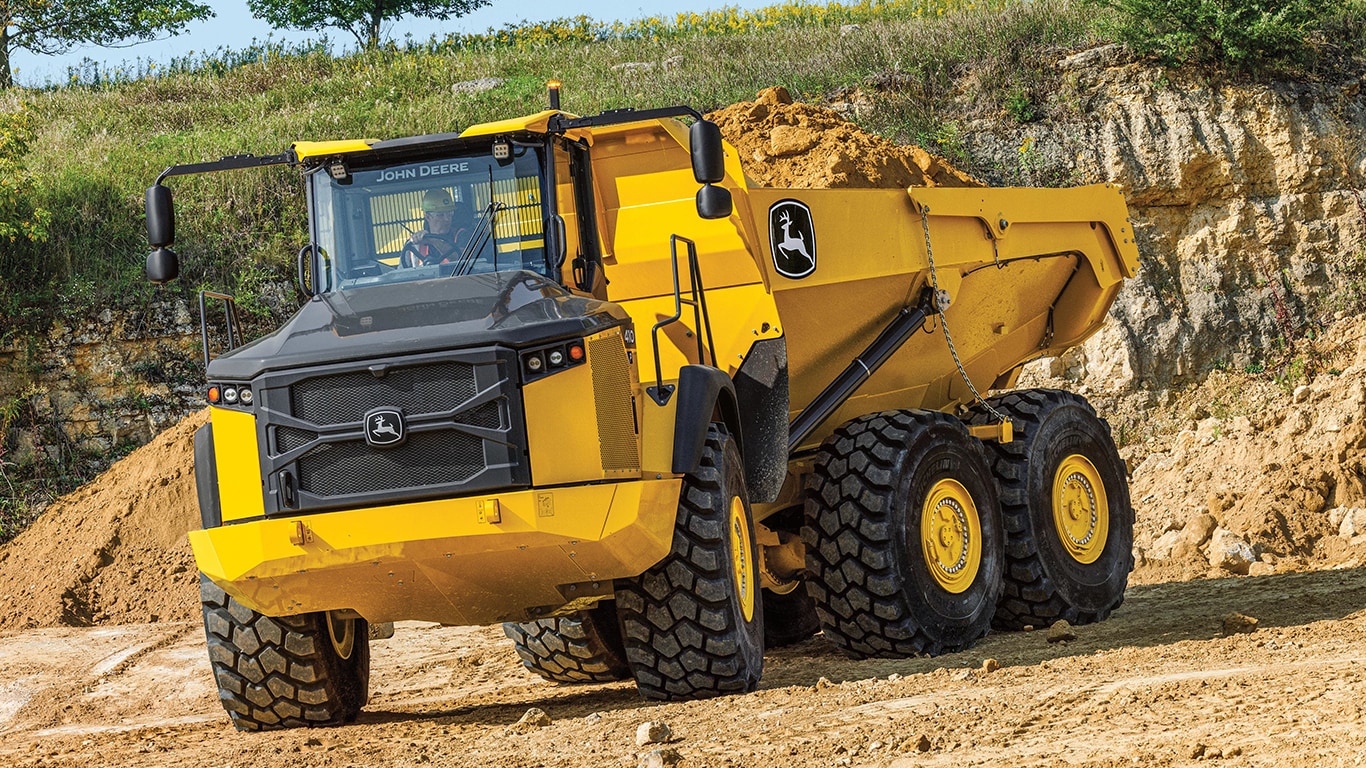 Un camion-benne articulé 460P avec de la saleté dans le lit sur un chantier.