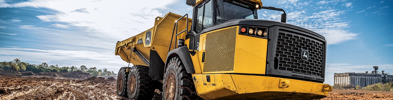 Camion-benne articulé John Deere travaillant sur le chantier.