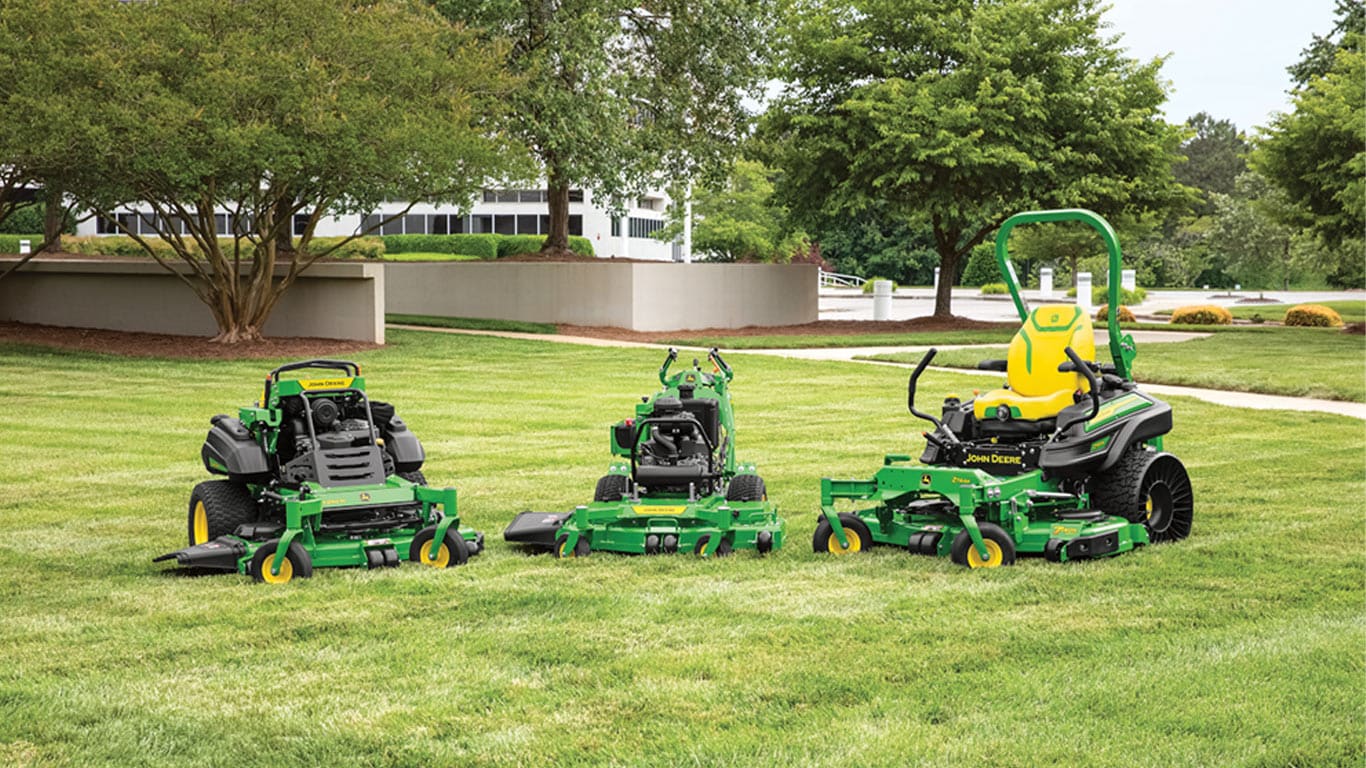 E, M & R Series QuikTrak™ Stand-On Mowers standing side by side in a field.