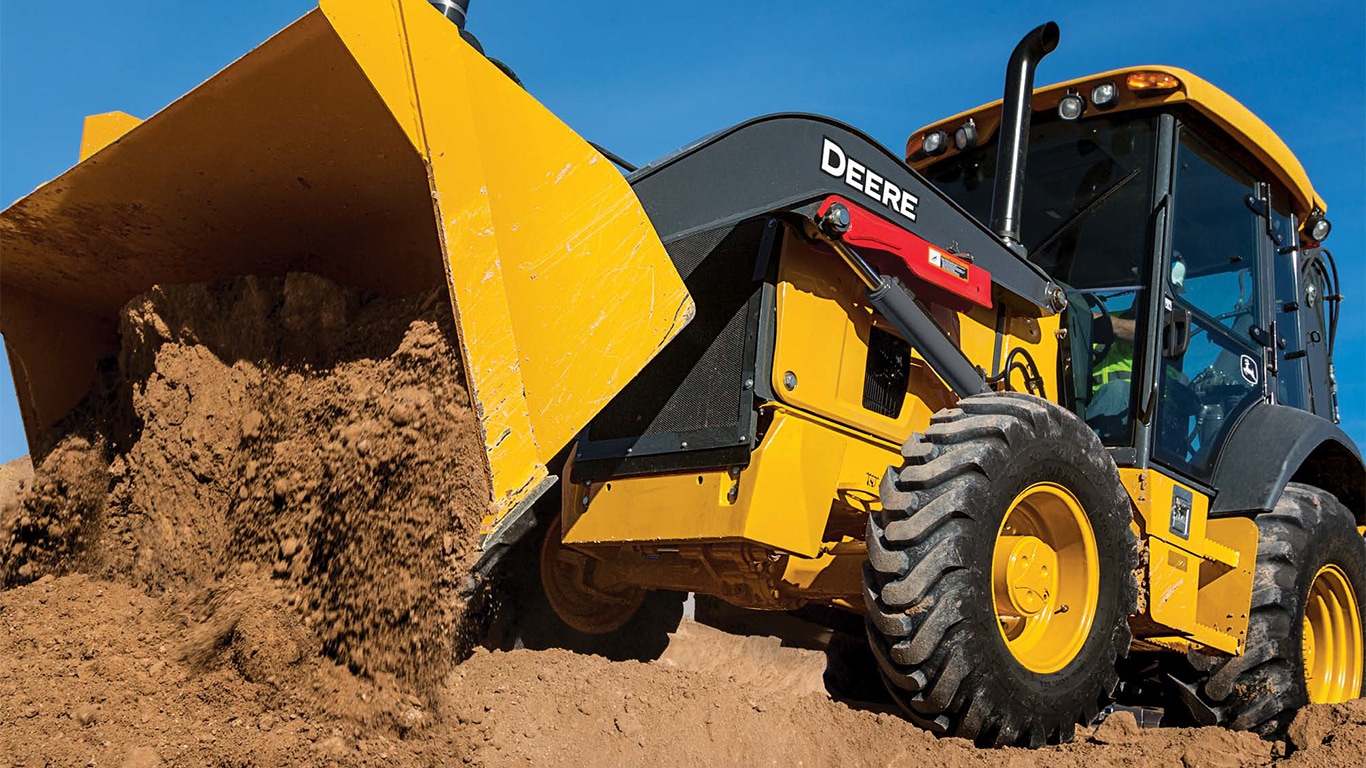 A 310P Backhoe dumping dirt from the bucket.