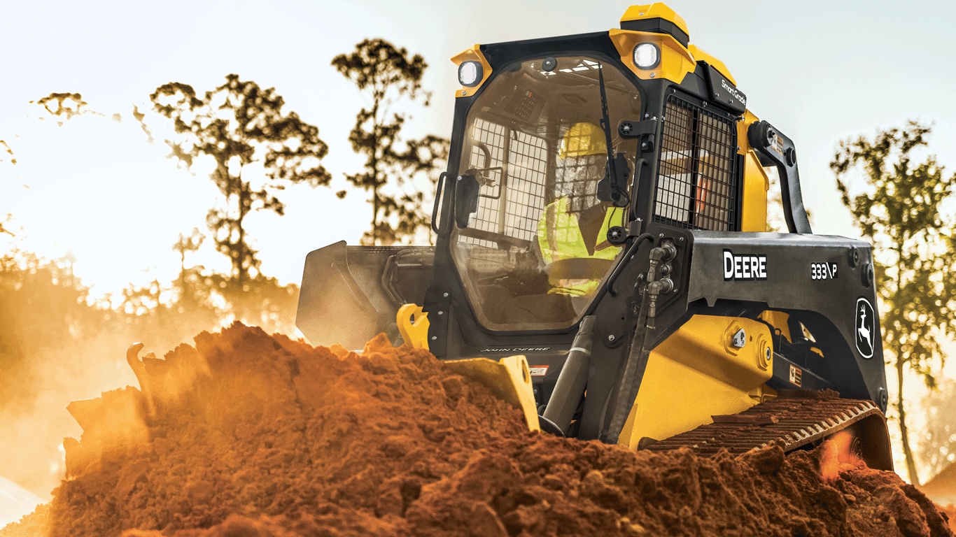 333 P-Tier compact track loader using blade to push dirt.