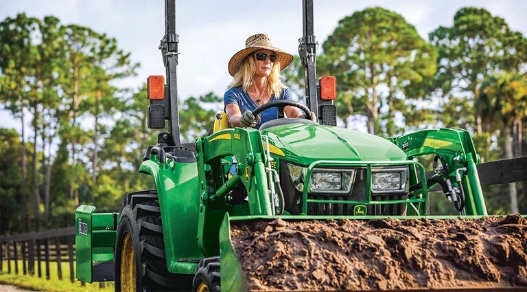 A person moving dirt with their 3025E Tractor.