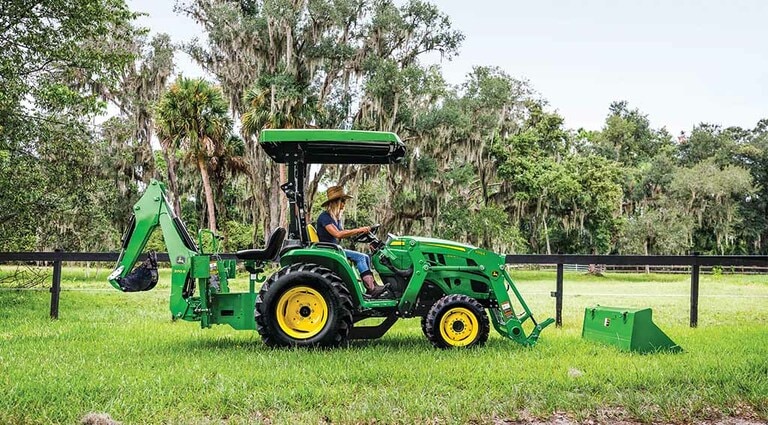 Une personne s’apprêtant à fixer un accessoire à son tracteur 3025E