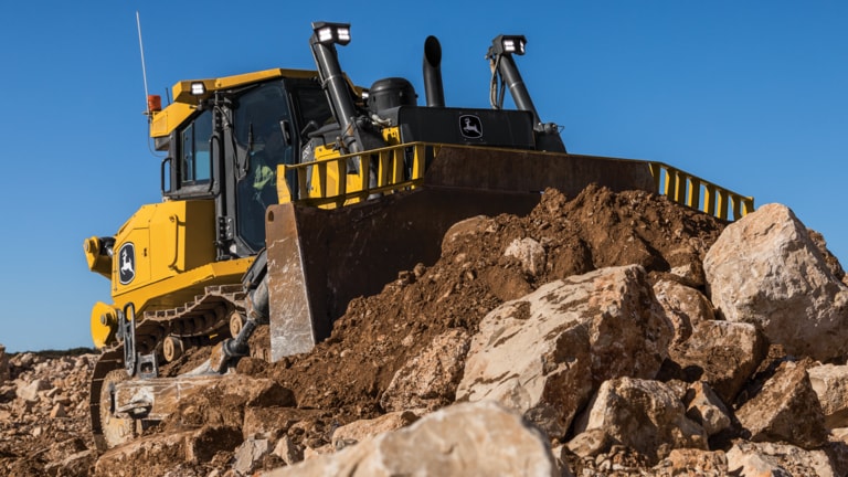 Un bouteur 1050 de catégorie P déplace de la pierre sur un chantier.