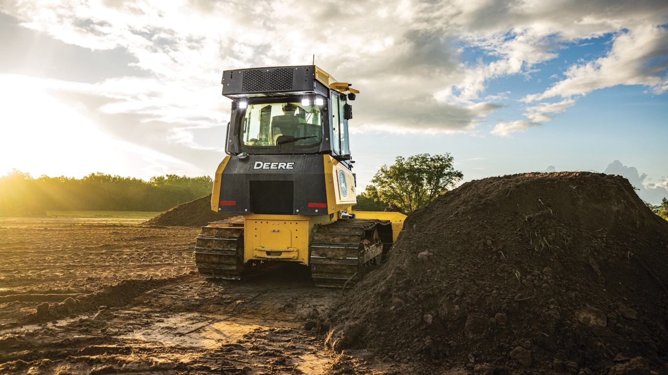 Rear view of a 450P Dozer next to a topsoil stockpile.