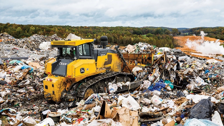 Un bouteur 950K poussant les déchets dans des tas au niveau d’une décharge.