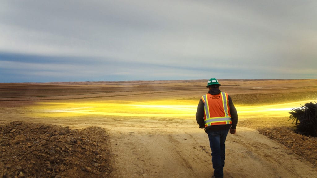 Chemin de lumière jaune passant devant un ouvrier du bâtiment sur un chantier.