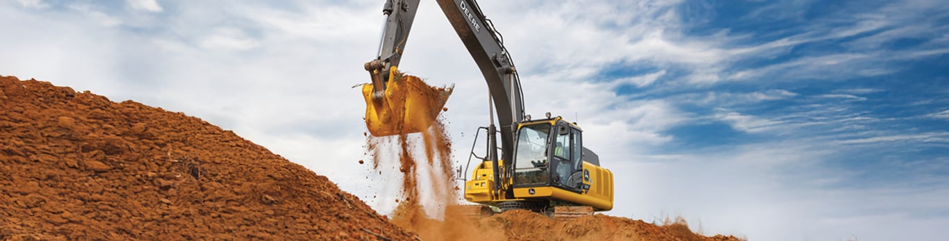 Excavatrice John Deere travaillant sur le chantier, d&eacute;pla&ccedil;ant les salet&eacute;s avec la benne.