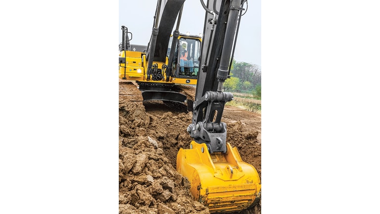 An operator using a 350P-Tier Excavator to scoop dirt out of a hole.