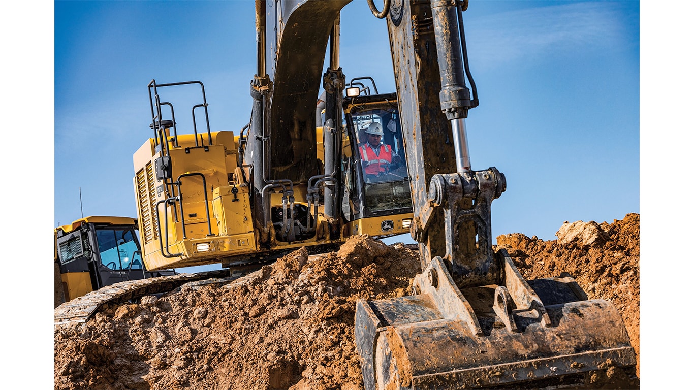 Un opérateur qui utilise une excavatrice 670P-Tier pour ramasser de la terre sur un chantier.